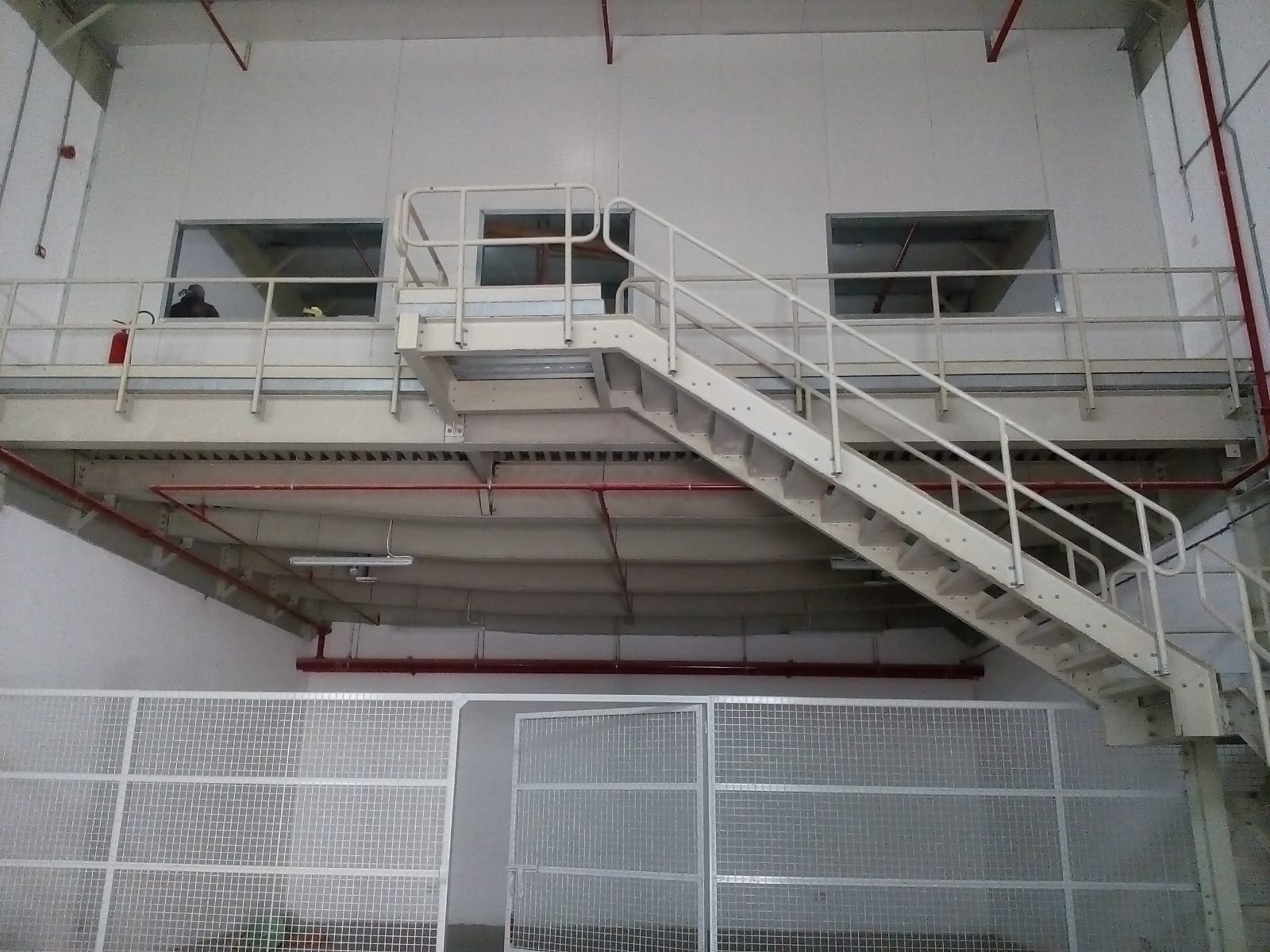 Industrial steel mezzanine platform with access staircase