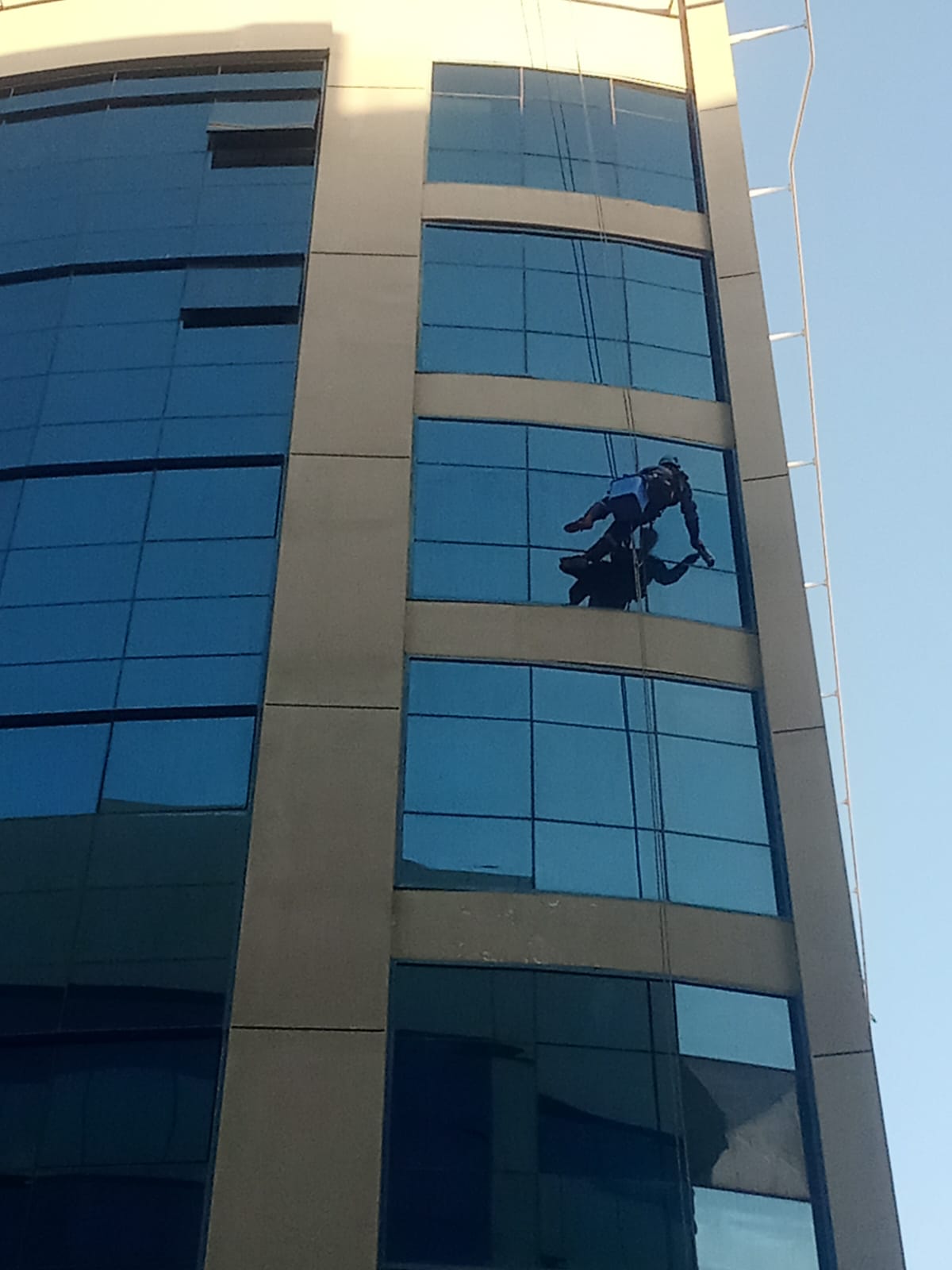 Rope-access facade work on glass tower